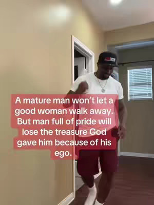 A man in a black cap, white t-shirt, and maroon shorts walks towards the camera in a brightly lit room. A red rectangular text overlay covers much of the scene, bearing a quote about the traits of mature men and men of pride.