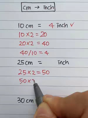 A close-up shot of a handwritten math problem converting centimeters to inches on a lined notebook. The top has text in a rectangle. The calculation steps including multiplication and division are shown, with annotations in black ink and a hand writing the last step with a pen..