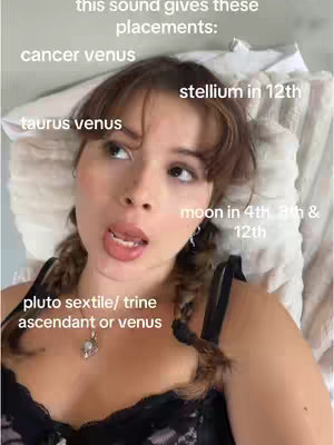 A selfie-style shot focusing on a young woman lying in bed with a pillow behind her. She is looking upward with an open mouth, as if speaking or reacting. Text overlays indicate astrology topics; specifically referencing placement and venus positions. This photo has a natural lighting and composition.