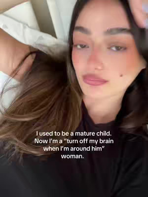 A woman with long brown hair is lying down, looking up at the camera. She has fair skin, rosy cheeks, and full lips. The text overlay is in white and describes her thoughts on a relationship.