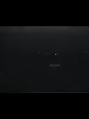 The image is predominantly black with a horizontal band of light across the center, suggesting a cityscape or horizon with faint lights. Several smaller, scattered, white dots resembling stars or distant lights are also visible. The overall composition is minimalist and nocturnal.