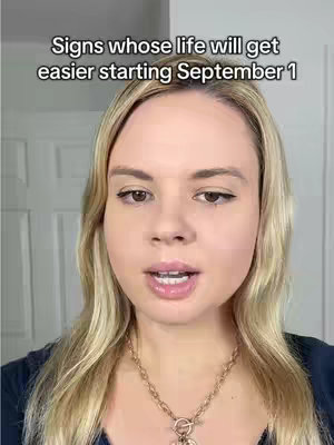 A woman with blonde hair and a gold necklace filmed from the chest up. Above her head is the text overlay, with a white background behind it. The background is a light-colored door and wall.