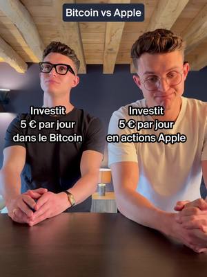 Two men stand side-by-side, each with text overlays indicating a financial investment scenario. The man on the left, wearing glasses and a black shirt, is juxtaposed with text saying 'Investit 5 € par jour dans le Bitcoin.' The man on the right, wearing a white t-shirt and glasses, is paired with the text 'Investit 5 € par jour en actions Apple'. The background consists of a neutral wall and wooden ceiling.