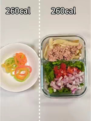 An image showing two food portions side by side. On the left is a white bowl with colorful vegetable ribbons. On the right, a transparent container has a food divided into compartments, containing tuna with pasta, lettuce, tomatoes, and red onion. Above the bowl and container are the text '260cal'.