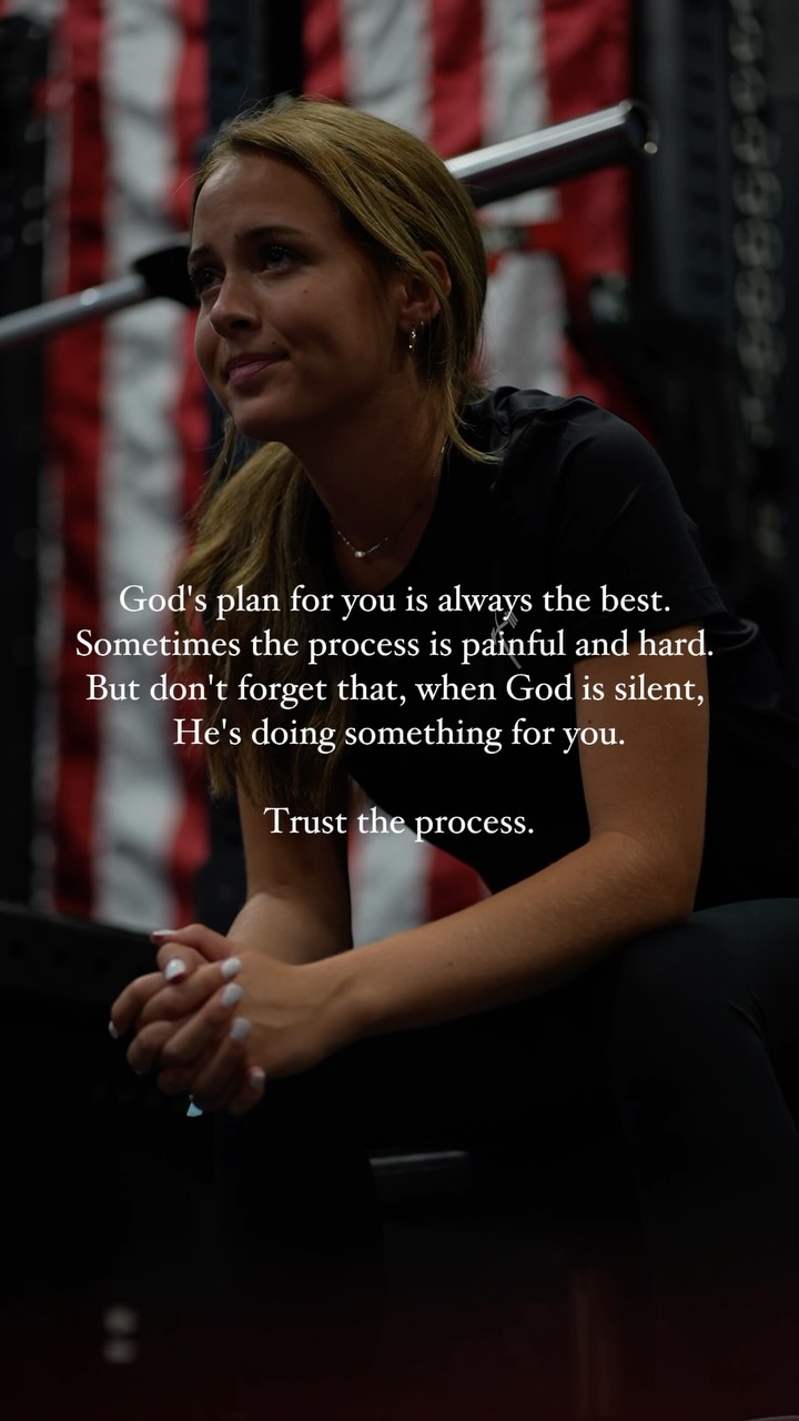 The image shows a young woman sitting, with a slightly upward gaze. She's wearing a black top, and her hands are clasped in front of her. The background is blurred but appears to include a backdrop with red and a blue/white stripes. Text overlay in a sans-serif font. Warm lighting.