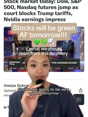 The cover image is a vertical shot featuring a woman in front of a screen displaying financial news. A text overlay that reads "Stocks will be green AF tomorrow!!!" is a key element, accompanied by green heart, four-leaf clover and an upward trending graph emojis. The woman is holding a microphone and speaking, suggesting commentary or analysis. The background shows a news broadcast with various financial data.