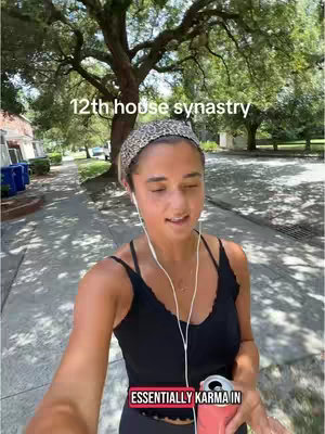 The cover image is a selfie-style video shot of a woman walking along a sidewalk. She is wearing a leopard-print headband, a black top, and holding a can of a pink beverage. She is wearing white earbud style earphones. The background includes a tree, some houses, and a road.