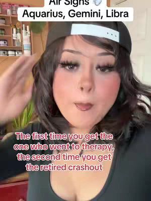 A selfie-style shot featuring a person with dark hair wearing a black baseball cap and makeup, including prominent blush. Text overlays are positioned at the top and bottom of the frame. The person is making a facial expression.