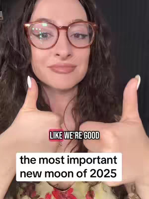 A woman with curly brown hair and round glasses smiles, giving two thumbs up. The image includes two overlaid text boxes, one saying 'LIKE WE'RE GOOD' and another saying 'the most important new moon of 2025'.