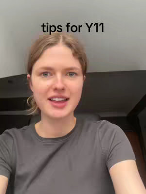 A selfie-style video cover featuring a fair-skinned woman with light brown hair who is looking directly at the camera and smiling. The text overlay at the top reads 'tips for Y11'. The background is a simple, neutral gray, likely a wall or other indoor space.