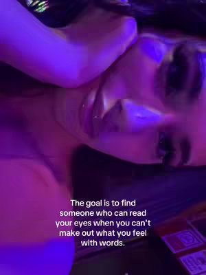 A close-up shot features a woman's face, primarily focusing on her eyes and the area around them. The lighting is predominantly purple, creating a dramatic and moody atmosphere. Overlayed on the image is text describing the goal of finding someone who understands your feelings without words.