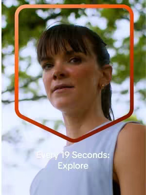 A woman with dark hair and bangs is framed in the upper half of the image, facing slightly to the left. She's set against a blurred background of green foliage, with a red-orange outlined shape around her. Text overlays are present at the bottom of the image.