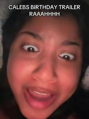 A close-up shot of a woman with wide, surprised eyes and an open mouth, likely reacting to something exciting. The lighting is warm, and the background is blurred.