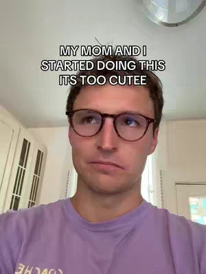 A man wearing glasses is looking down with an unamused expression. Overlay text in white informs the viewer “MY MOM AND I STARTED DOING THIS, ITS TOO CUTEE”. The background appears to be a room with a bright light overhead.