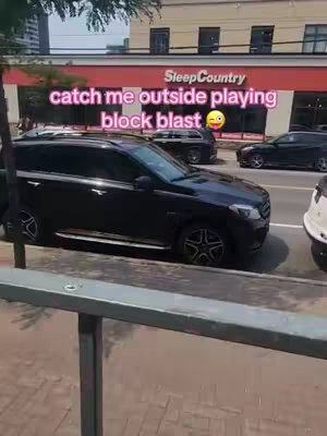 A street scene with a black car parked in front a SleepCountry store, with pink text overlayed on the image.