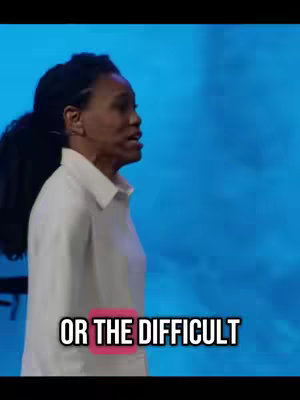 A woman is speaking in front of a blue background. Text overlayed on the video states "OR THE DIFFICULT".
