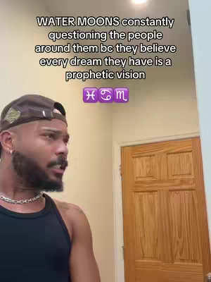 A man with a beard and a baseball cap looks off to the side in a room. Text overlays the image with a message about water moons in astrology and their supposed prophetic visions.