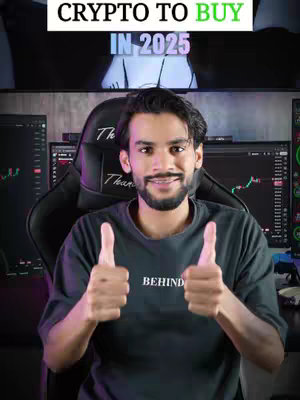 A man with a beard and a grey t-shirt sits in a gaming chair, gives a thumbs-up, and displays two computer screens with charts and graphs. A text overlay states “CRYPTO TO BUY IN 2025”.