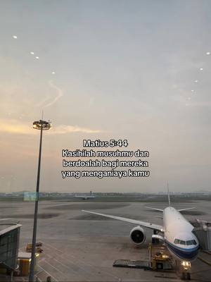 The cover image shows a view from an airport window, with a large airplane parked outside. Text in Indonesian overlays the view.