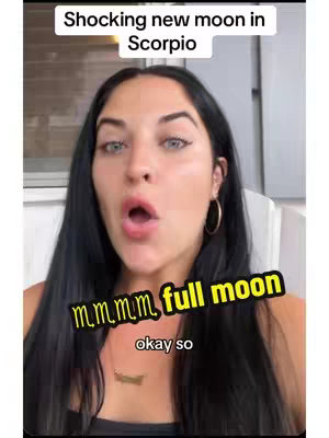 A woman with dark hair is centered in the frame, looking towards the camera with her mouth open in an 'O' shape. Above her, text reads, 'Shocking new moon in Scorpio.' Overlayed text in a yellow font says 'm,m,m,m, full moon' with 'okay so' beneath it.