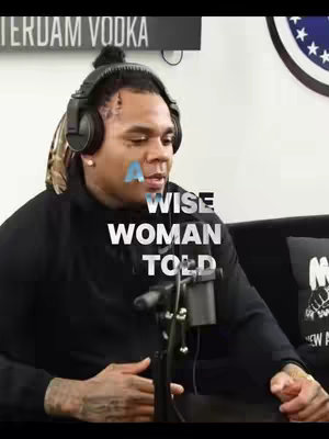 The cover image features a man wearing headphones, facing slightly to the side while looking downwards. Text is overlaid on the image reading, "A wise woman told". The background is blurred, but a black microphone is visible. A logo is also present on a pillow.