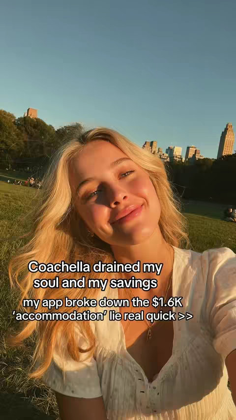 A selfie-style shot of a young woman with blonde hair smiling softly. The background features a lush green park with buildings silhouetted against a clear sky. Text overlays on the bottom: 'Coachella drained my soul and my savings my app broke down the $1.6K "accommodation" lie real quick >>'.