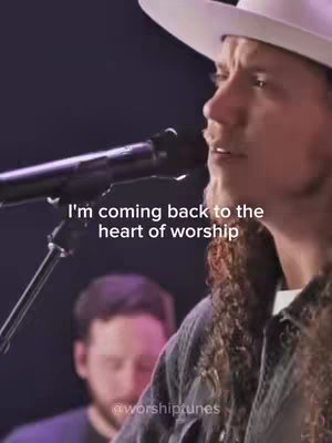 The cover image features a profile shot of a man in a cowboy hat singing into a microphone. The background is dark, with another person slightly out of focus in the background. Text overlayed on the image reads "I'm coming back to the heart of worship."
