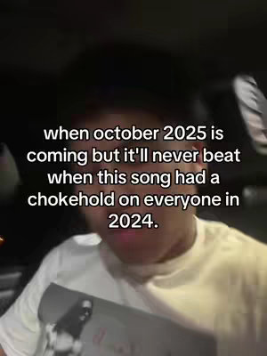 A person in a white shirt is sitting in a car, most likely in the driver's seat. The person seems to be looking directly at the camera, which is positioned slightly from below. Text appears on the screen and has an emotional sentiment.