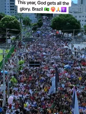 An aerial shot shows a large crowd of people gathered outdoors. The image is filled with people, many holding umbrellas that add a splash of color. The composition features a wide angle view, showing the vastness of the crowd. Above them, text overlays indicate the theme of the video’s content.