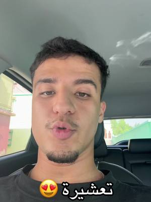 A selfie taken from inside a car, with a man looking directly at the camera. The man has short dark hair, a mustache, and a small goatee. The background shows the car's interior.