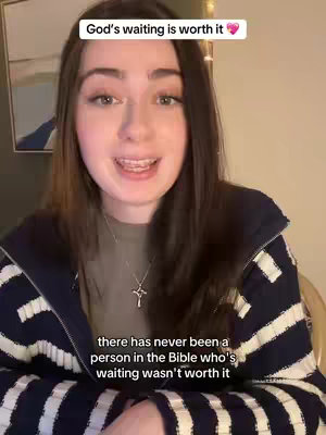 A young woman with long brown hair and braces is centered in the frame, speaking directly to the camera. She wears a navy blue and white striped jacket over a light-colored shirt and a silver cross necklace. The background is a blurred room with a piece of framed art visible. Text overlays at the top and bottom of the image convey a message.