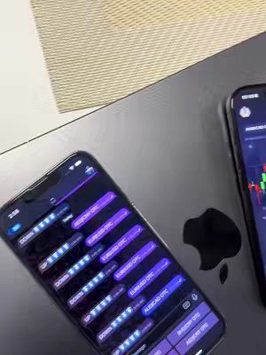 The cover image shows two smartphones lying on a dark surface, possibly a laptop; the Apple logo indicates it is the top of a Macbook. Both phones display app interfaces with financial charts and data, likely related to trading. Text overlays and a prominent 'Signals bot' label the content. The lighting is bright and the overall feel is professional and tech-focused.