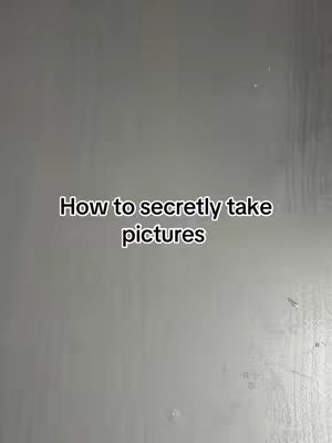 The cover image features a solid gray background. In the middle of the frame, there is black text that reads "How to secretly take pictures". The text is horizontally centered.