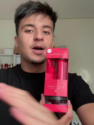 A man with short, dark hair is holding a red gift set from "Rituals." He is looking at the camera, and the gift set fills most of the frame.