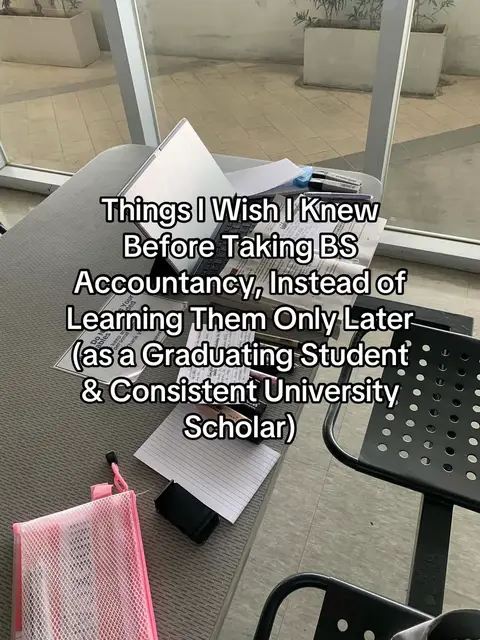 The image shows a top-down view of a workspace. A closed laptop is prominently placed with papers and pens scattered around. Text overlays indicate the video's topic, and a pink pencil case adds a pop of color. The setting suggests a study or work environment.