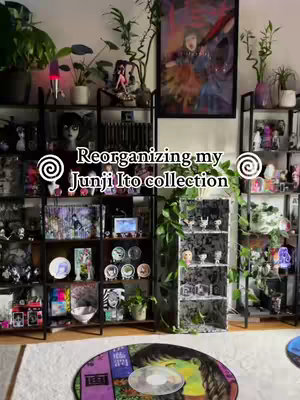 The image shows a room with shelving and plants, showcasing a collection of Junji Ito manga and merchandise alongside anime figures and framed artwork.