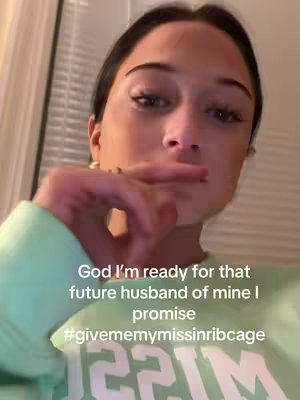 A woman's face fills the frame from a slightly low angle, her expression focused. Her hand is raised to her mouth. Overlayed text in white font is present, setting the stage for the future and romance.