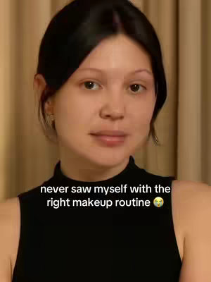 A woman with dark hair is centered in the frame, looking directly at the camera. She wears a black top. Below her, the text overlay reads, "never saw myself with the right makeup routine" with a questioning emoji.