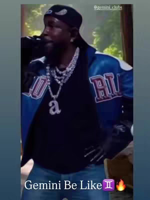 The cover image features a man, likely the creator, dressed in a blue and white jacket with what appears to be a logo. He is wearing multiple necklaces and a black hat with a white emblem. A text overlay is placed at the bottom with a zodiac sign and flame emojis.