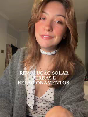 A young woman with long brown hair and a light gray cardigan smiles at the camera. Overlayed text in white states "REVOLUÇÃO SOLAR PERDAS E RELACIONAMENTOS". The background is softly blurred, suggesting an interior setting.