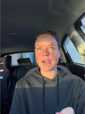 The cover image features a person with fair skin and blue eyes, wearing a gray hoodie, sitting inside a car. The background shows the car's interior and a glimpse of the outside through the windows. The lighting suggests it's daytime.