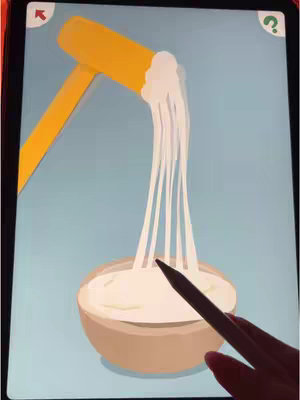 The cover image shows a tablet screen with a game interface. The game seems to involve pouring a thick, white liquid (possibly cream or glue) from a yellow spout into a brown bowl. A hand is shown using a stylus to interact with the screen. The background is a light blue color which provides contrast for the game elements. A red arrow and a question mark for a call-to-action is located at the top corners of the screen.