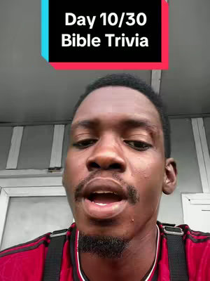 The cover image is a vertical shot featuring a Black man, shown from the chest up, in front of a background that appears to be an interior setting, possibly a home. The man is centered in the frame, with his face clearly visible, and appears to be speaking. Overlayed at the top of the image is a colored rectangle containing white text that reads "Day 10/30 Bible Trivia". The background is slightly out of focus, with muted tones, while the man is crisply in focus. He is wearing a red shirt with black stripes, and his expression indicates he is in the middle of speaking. The lighting appears to be natural or soft, creating minimal harsh shadows.