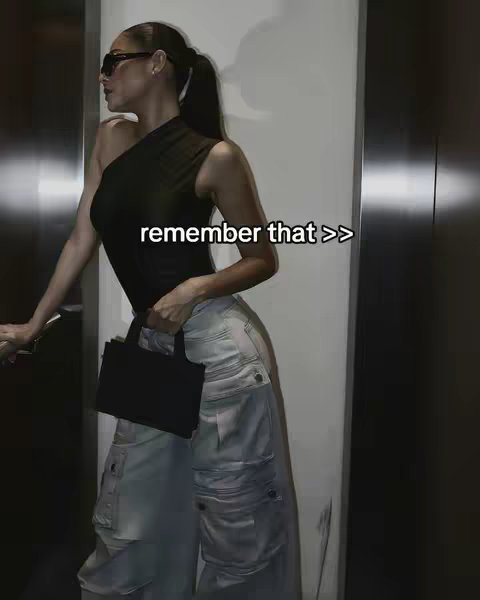A woman with sunglasses and a ponytail leans against a wall in a chic outfit. On the cover is the text "remember that >>".