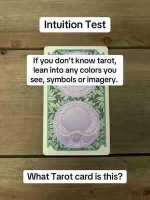 The image presents a wooden background, a tarot card with illustrations and text overlays.  The tarot card features a pattern of green leaves on the outer edges, and the inside of the card highlights a pair of round, light purple shapes. The prompt "Intuition Test" appears, with the message, "If you don't know tarot, lean into any colors you see, symbols or imagery.". The image concludes with the question, "What Tarot card is this?"