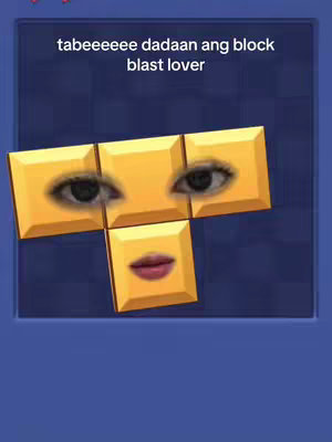 A digitally altered image of block game pieces, forming a stylized face. The blocks are yellow and have a smooth, slightly glossy texture. The eyes are realistic, set into two of the blocks, and the lips are a reddish-pink color, placed to represent a mouth. The background is a gradient of dark blue.