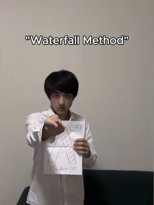 The cover image displays a young man in a white shirt holding a handwritten sheet of paper with a large, drawn 'A' in red strokes, along with additional writing. The text overlay at the top reads"Waterfall Method". The background is a plain, off-white wall.