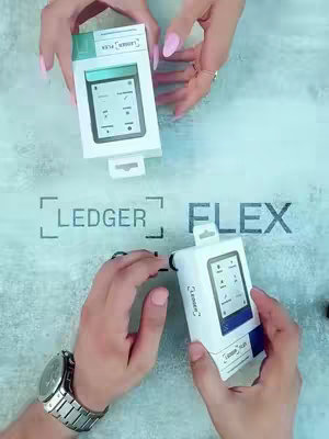 The cover image displays two hands holding the white boxes of a Ledger Flex device, with the "LEDGER FLEX" logo and the same product box printed on them. The scene is shot on a light, textured surface, with the boxes displayed in different angles, one in the foreground and one in the background.