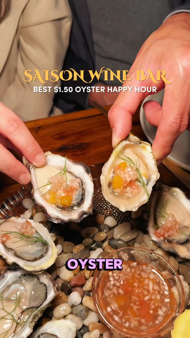 The cover image shows a top-down shot of a wooden table setting with several fresh oysters, some already eaten. Hands are holding two of the oysters, displaying their contents. A small clear bowl of sauce sits nearby, and the table is decorated with small stones. Text overlays on the image advertise the wine bar's happy hour oyster specials.