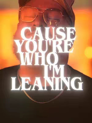 A close-up shot of a person, appearing to be a man, with a warm, orange and yellow gradient background. He wears glasses, an earring, and a gold chain, with bright, glowing text overlaid. The text says CAUSE YOU'RE WHO I'M LEANING.